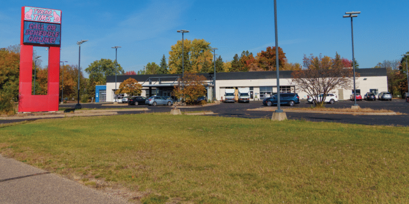 an outdoor view of an auto repair shop with a digital sign that says call or schedule online